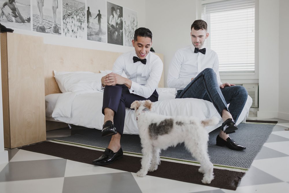 Two grooms getting ready together on wedding morning