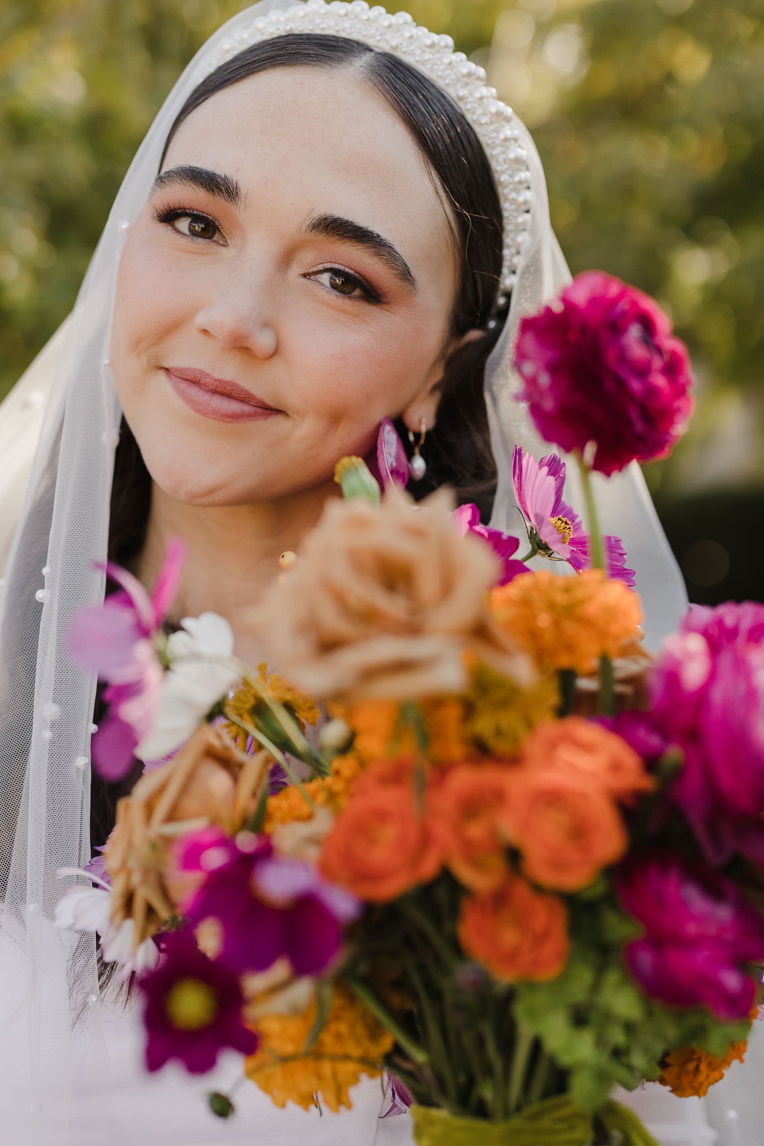Bride in pearl bridal headband with colorful bouquet by Flowerchild Florals