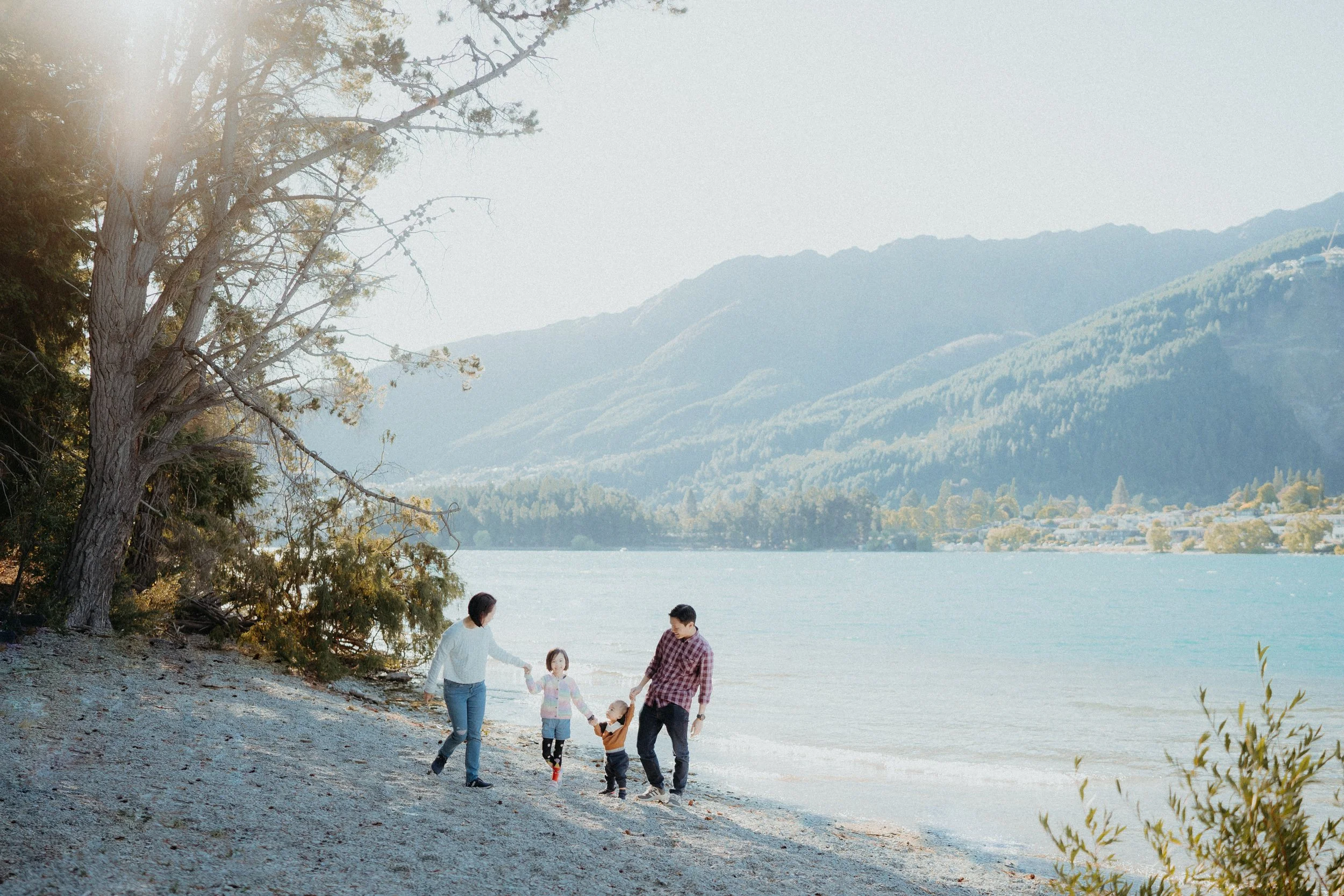 family holding hands walking beside water at kelvin heights
