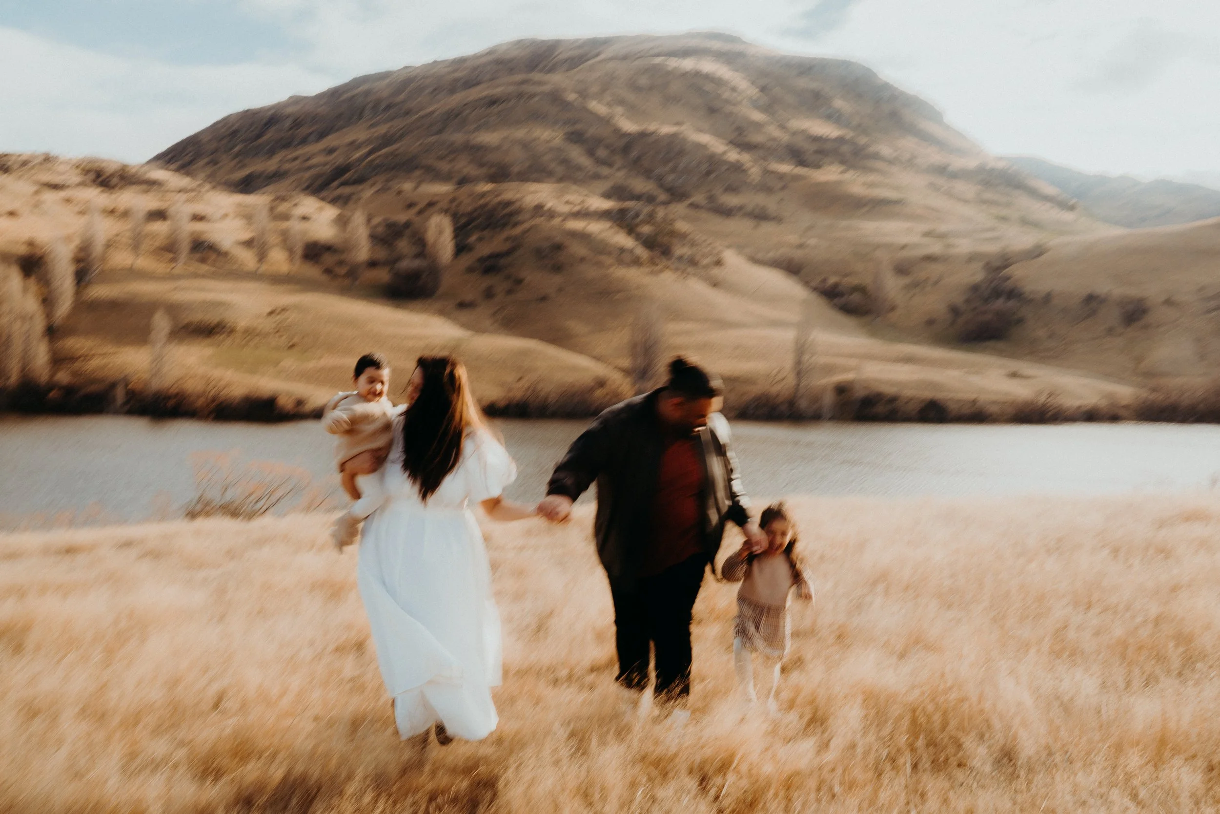 family posing in front of lake johnson
