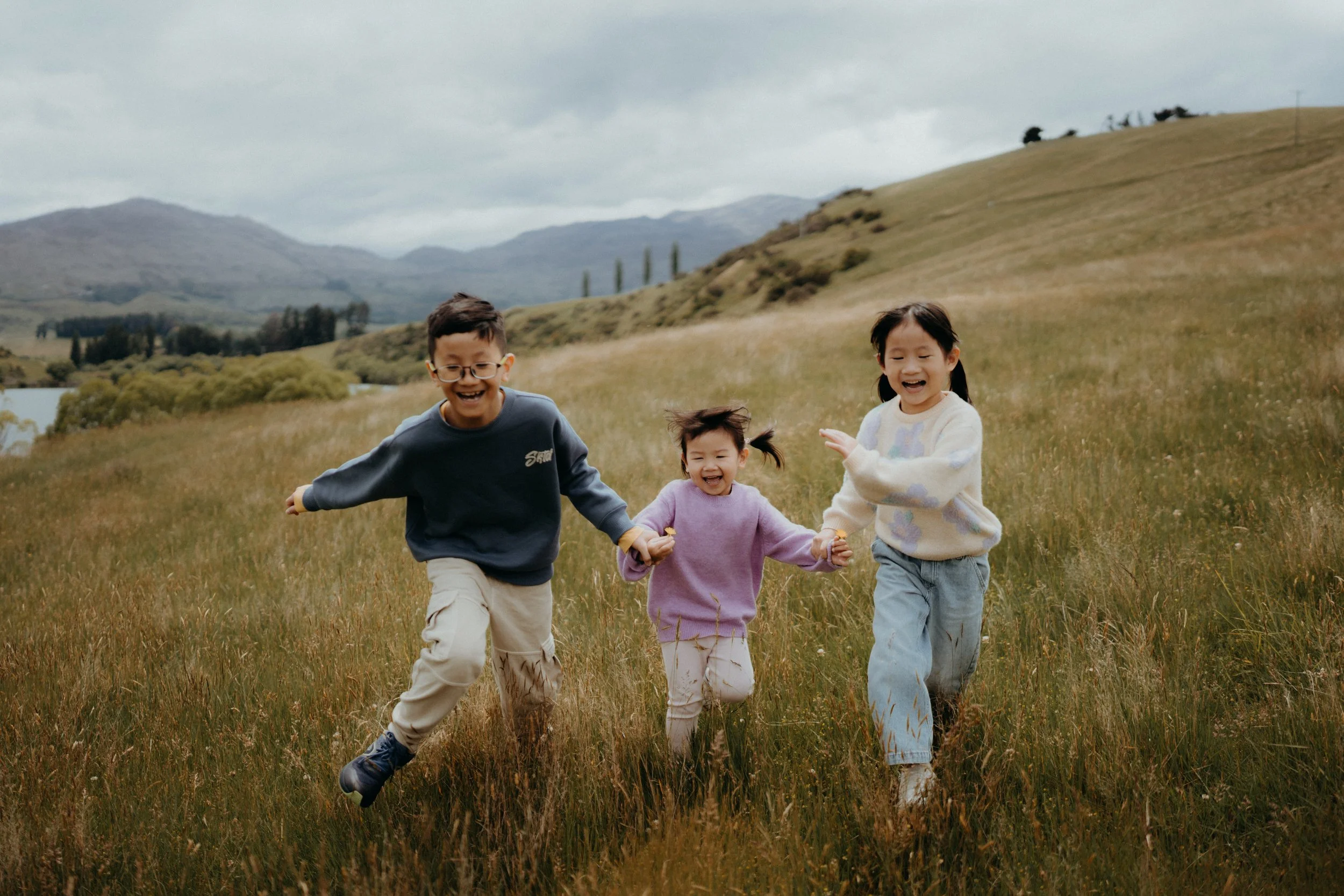Close up of children running through grassy meadow at Lake Johnson