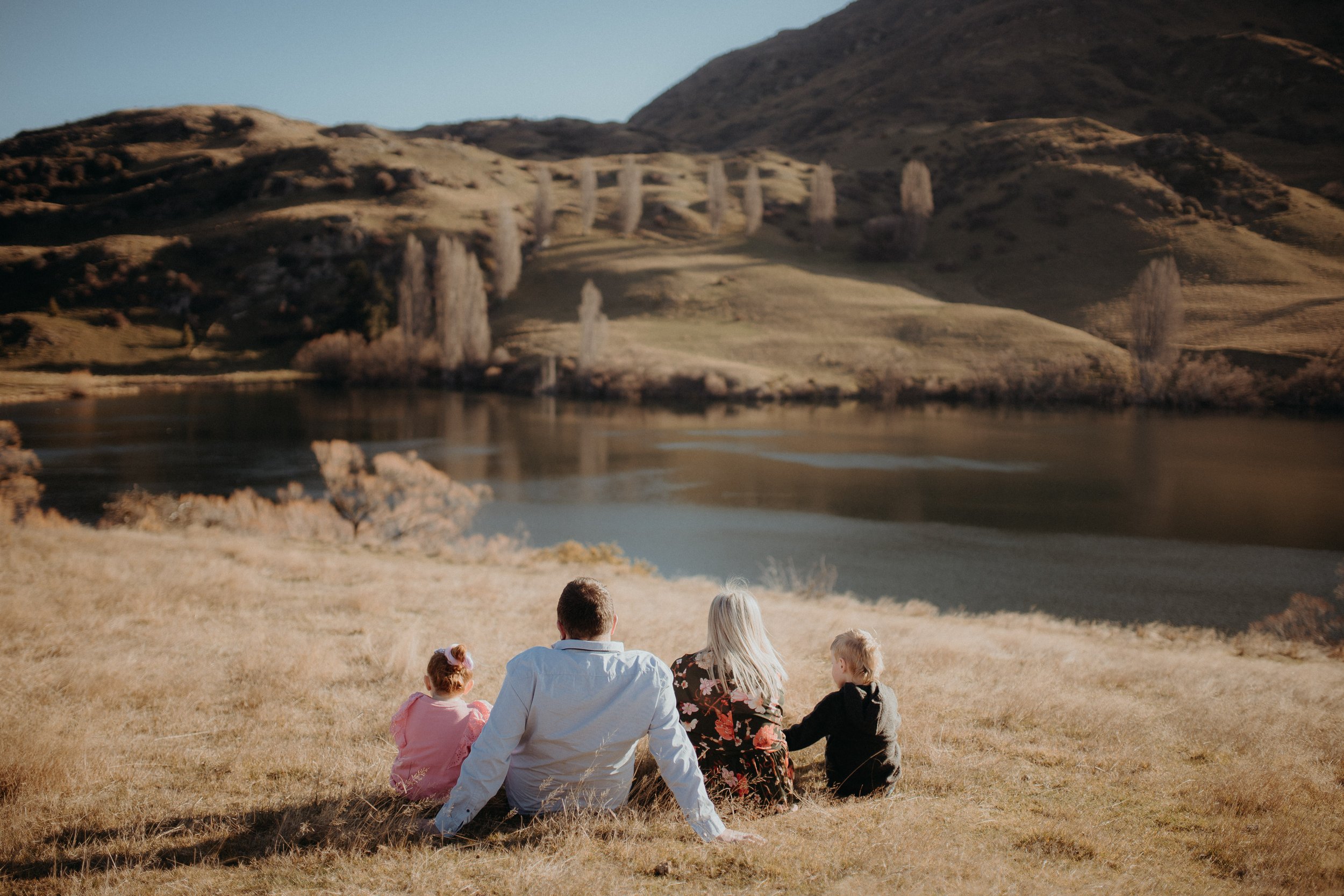 Family of 4 sitting and admiring the view of lake johnson