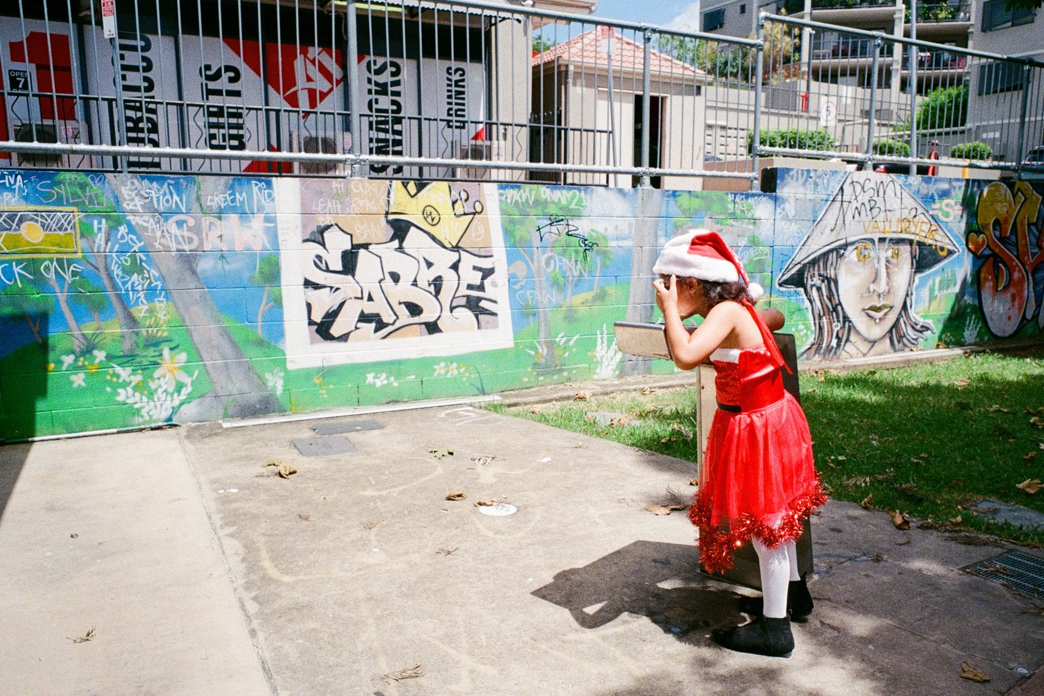 Girl in Santa costume drinking from a water fountain in Bunyapa park.