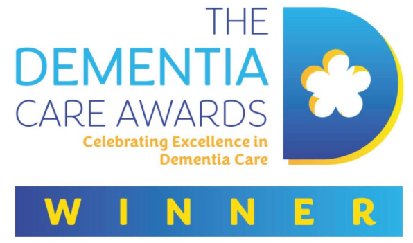 Logo for the Dementia Care Awards with the tagline 'Celebrating Excellence in Dementia Care' and the word 'WINNER' highlighted in yellow on a blue background.