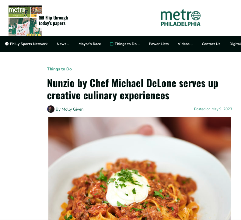 Close-up of a plate of pasta with meat sauce, topped with a dollop of sour cream and garnished with chopped herbs.