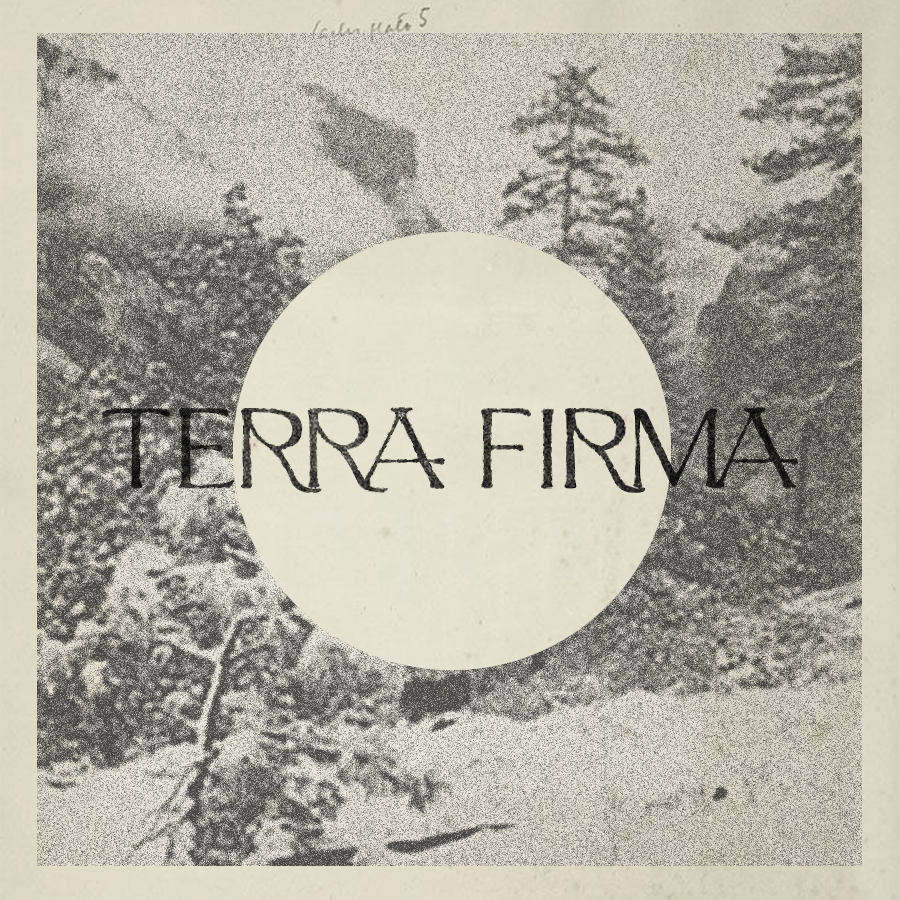 A black-and-white photograph of a snowy landscape with trees and mountains, overlaid with a large white circle and the words 'TERRA FIRMA' in uppercase letters.