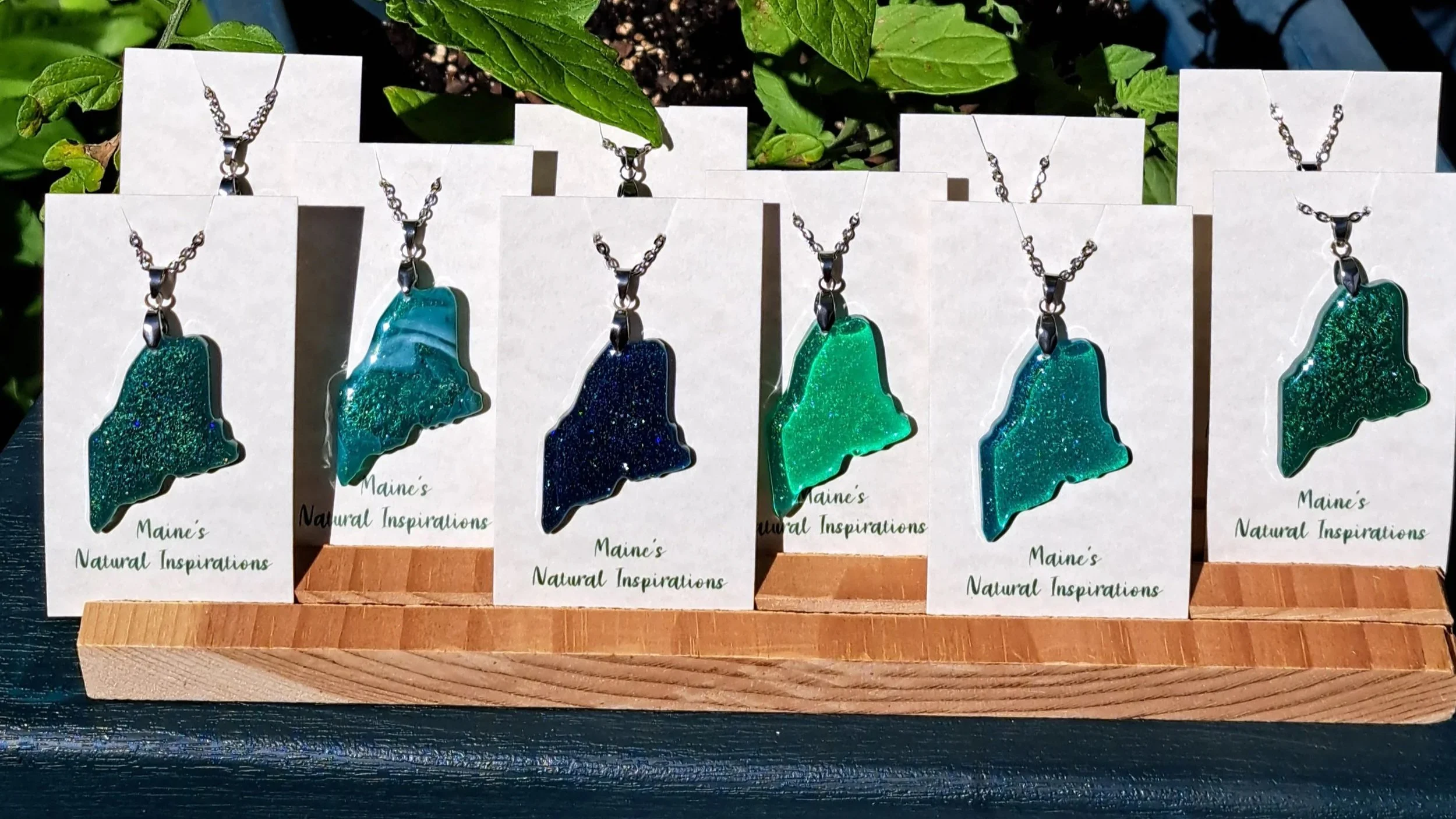 Maine shaped necklaces made with colored resin. Stainless steel necklace