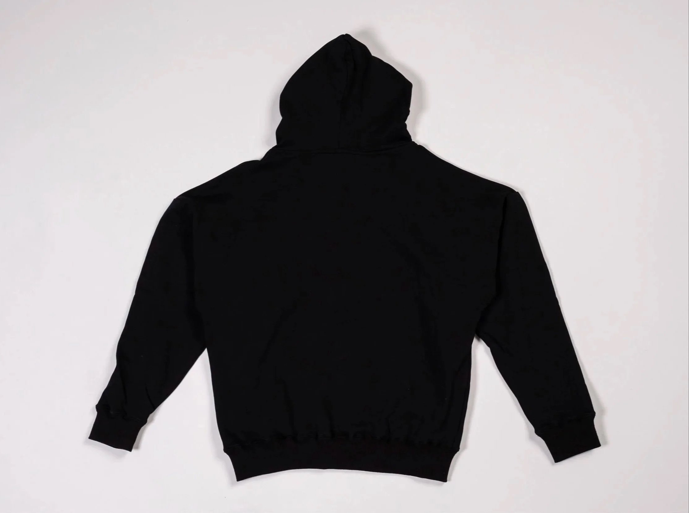 Back of black pullover hoodie with metallic chrome crucifix outline graphic on the front
