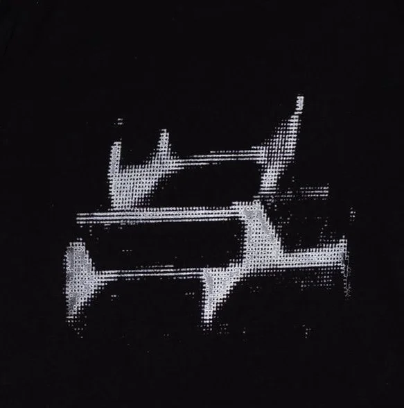 Close up of black t-shirt with small silver angular holographic-style halftone ‘HOM’ logo on chest and large silver holographic-style halftone ‘HOM’ logo across upper back