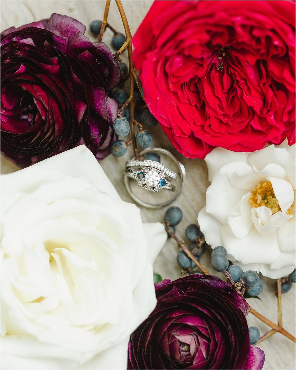 Unique Wedding Rings Surrounded by Florals and Winter Berries