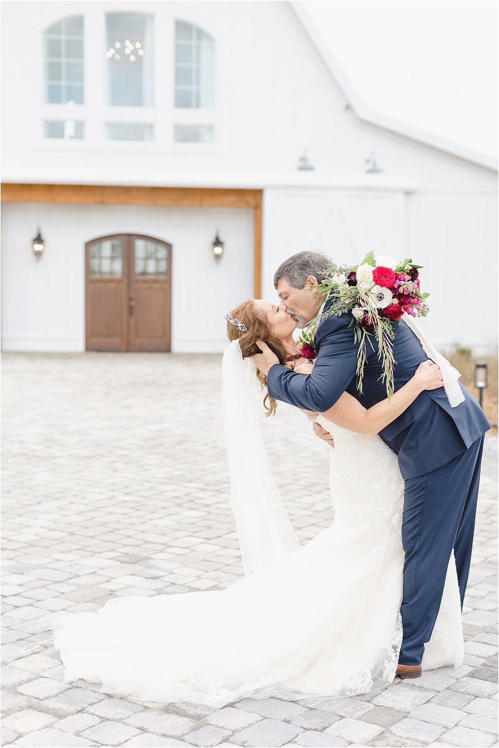 Bride and Groom Kissing in Front of Barn
