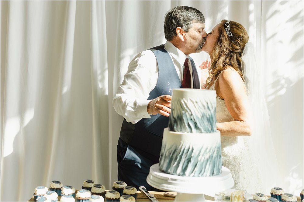 Bride and Groom Kiss While Serving Each Other Cake