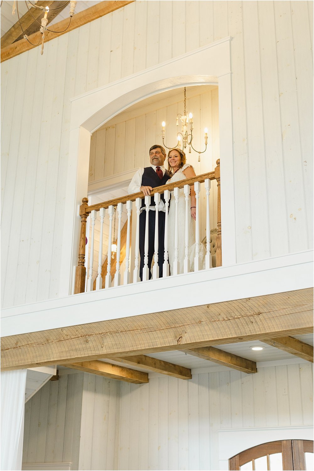 Bride and Groom Stand Over a Balcony