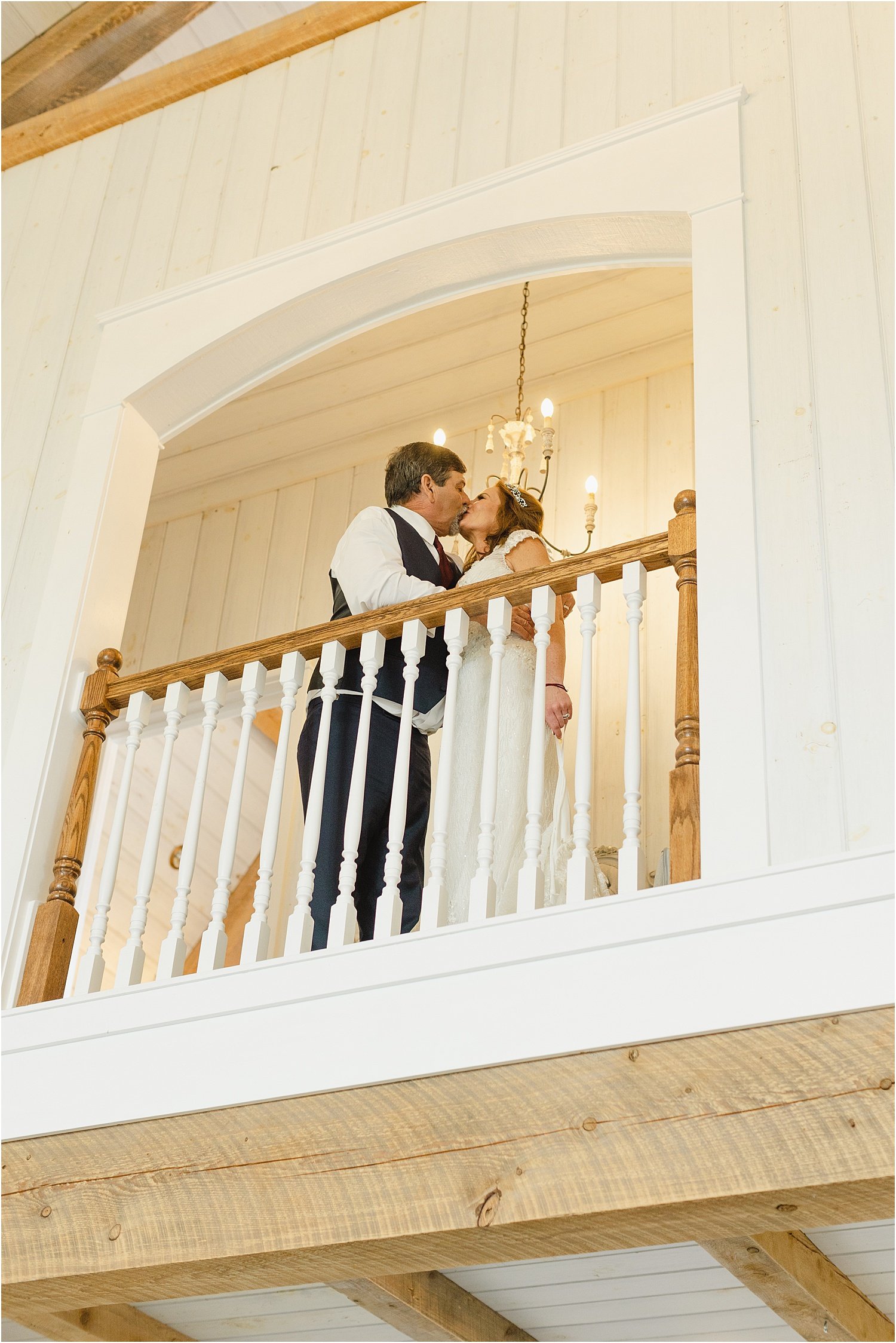 Bride and Groom Kiss at the Top of a Balcony