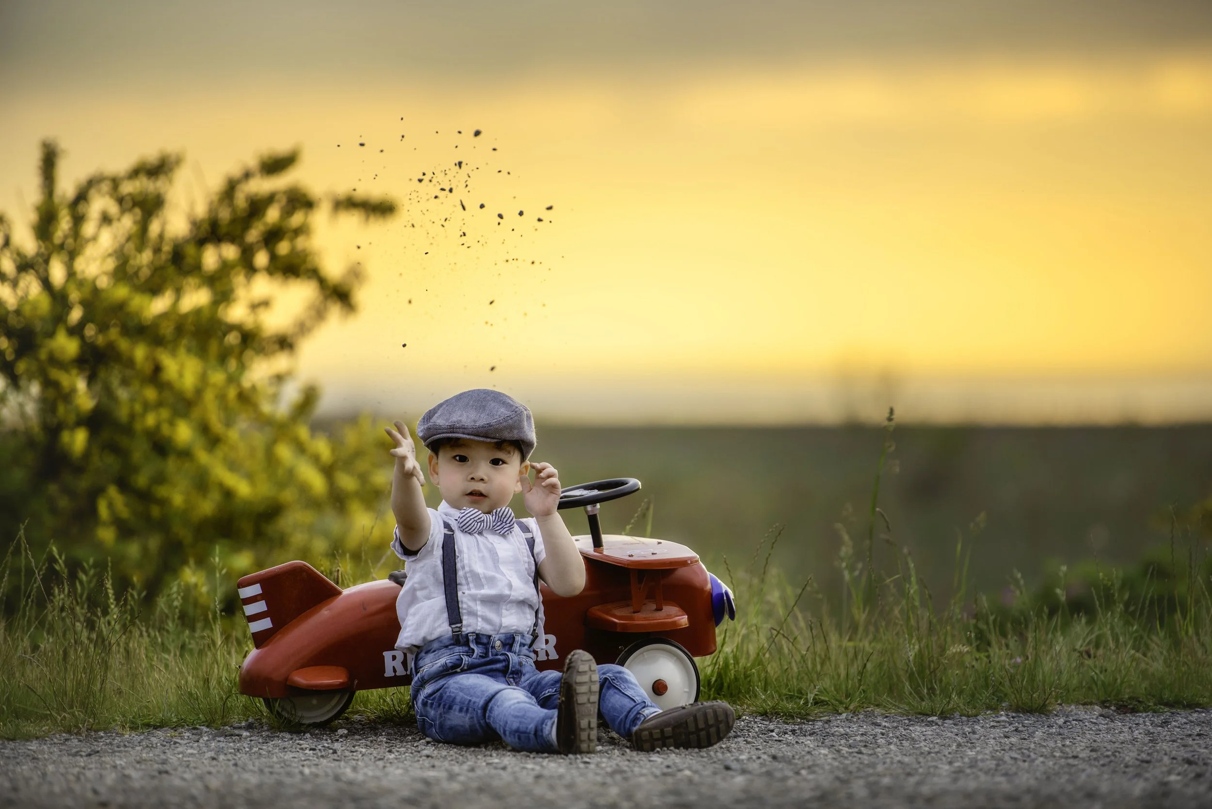 calgary children photographer boy planing with rocks.jpg
