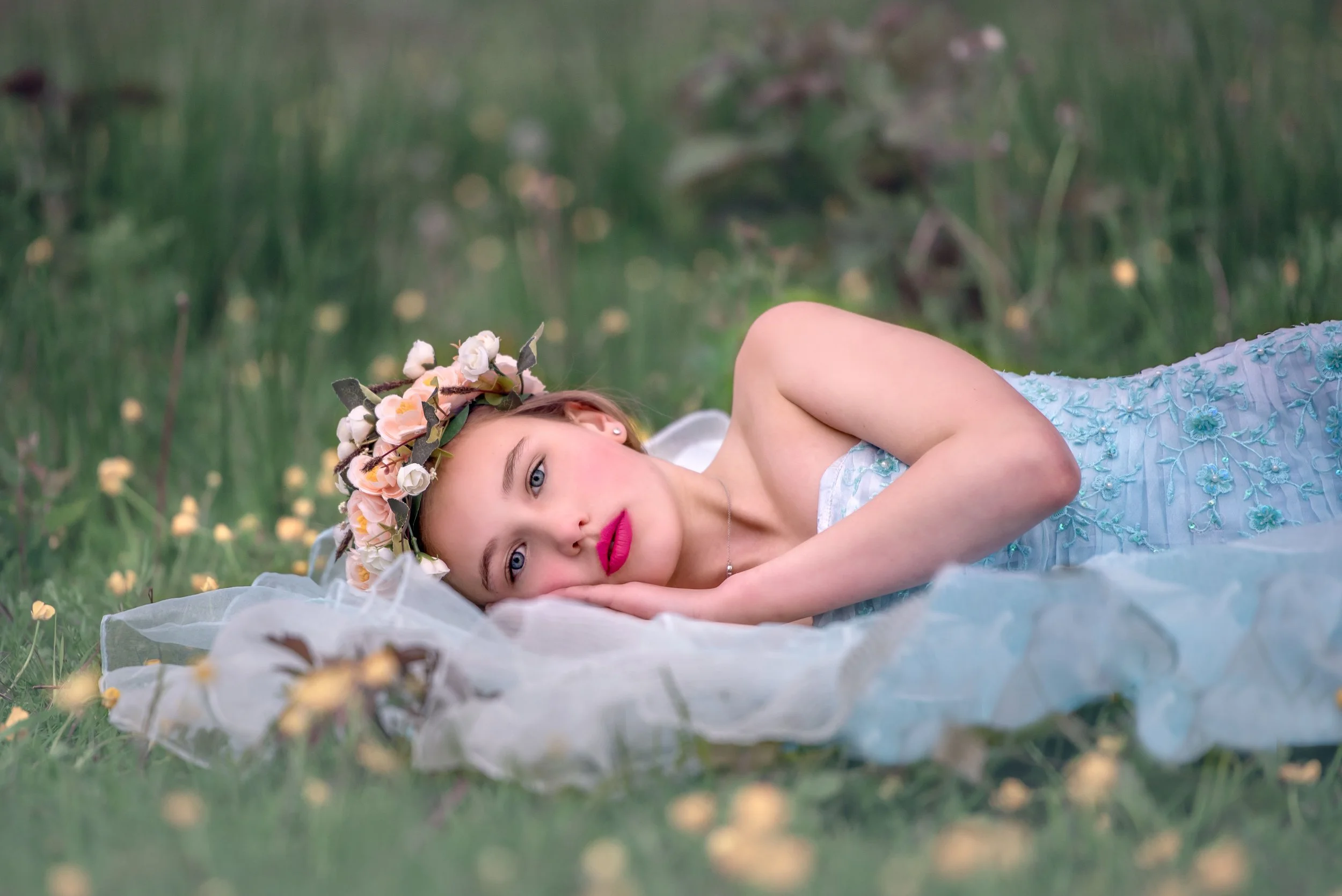 Calgary family photographer girl in blue dress lying on grass.jpg