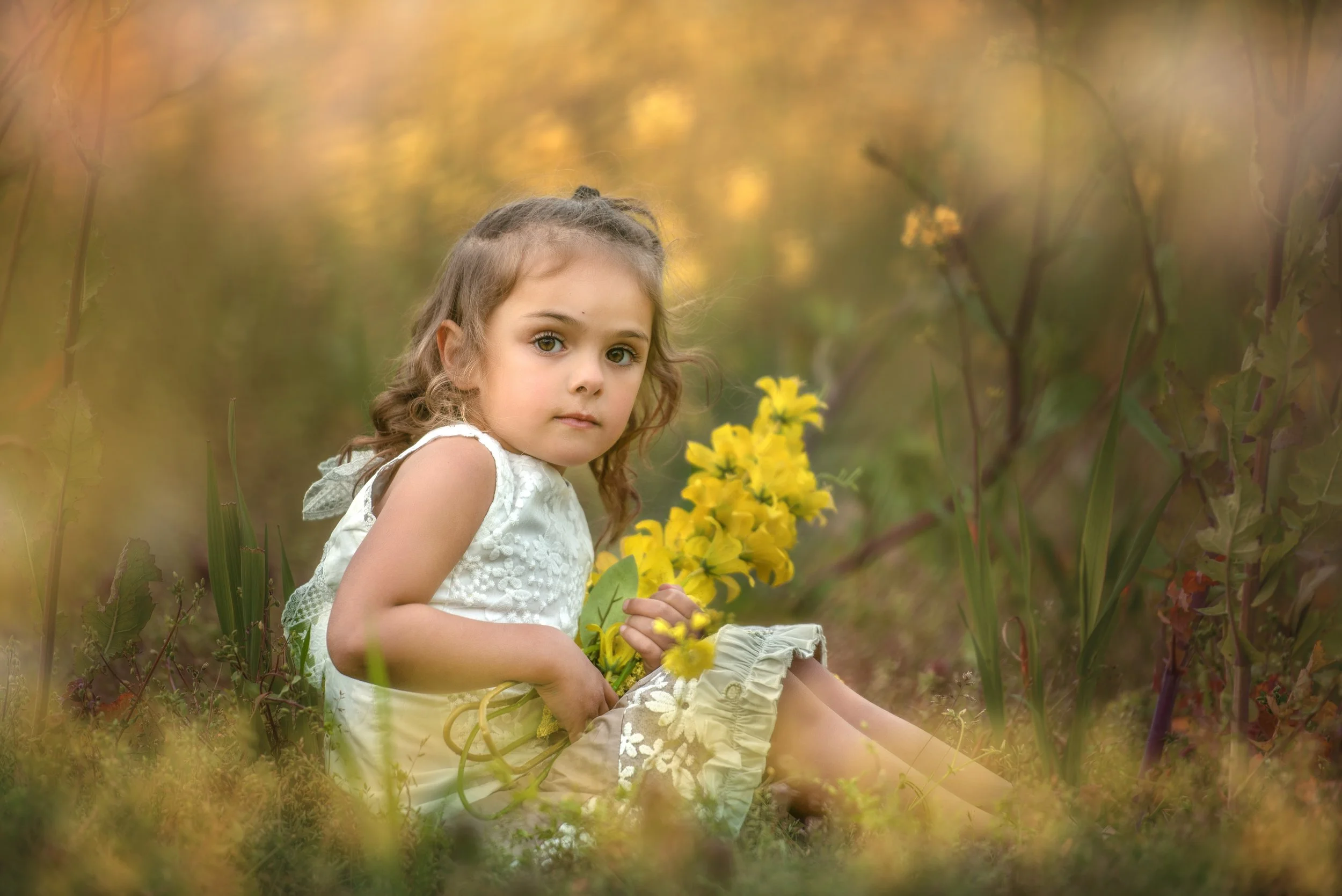 calgary children photographer girl sitting in field of flowers.jpg