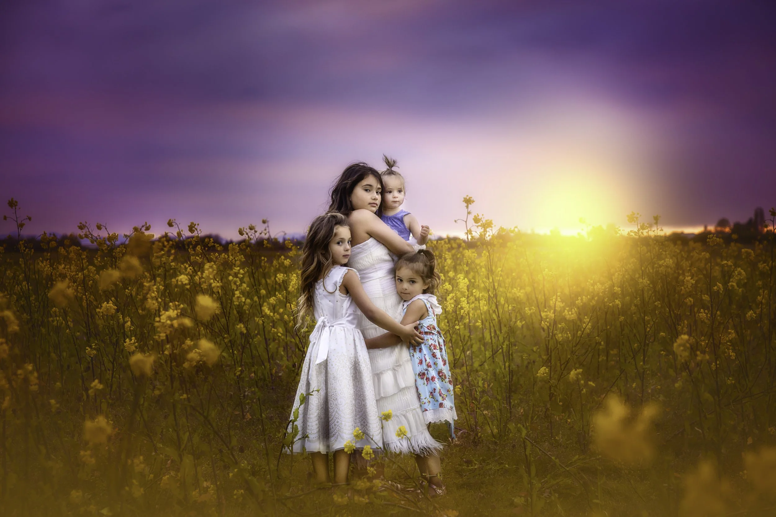 calgary children photographer 4 sisters hugging woldflowers.jpg