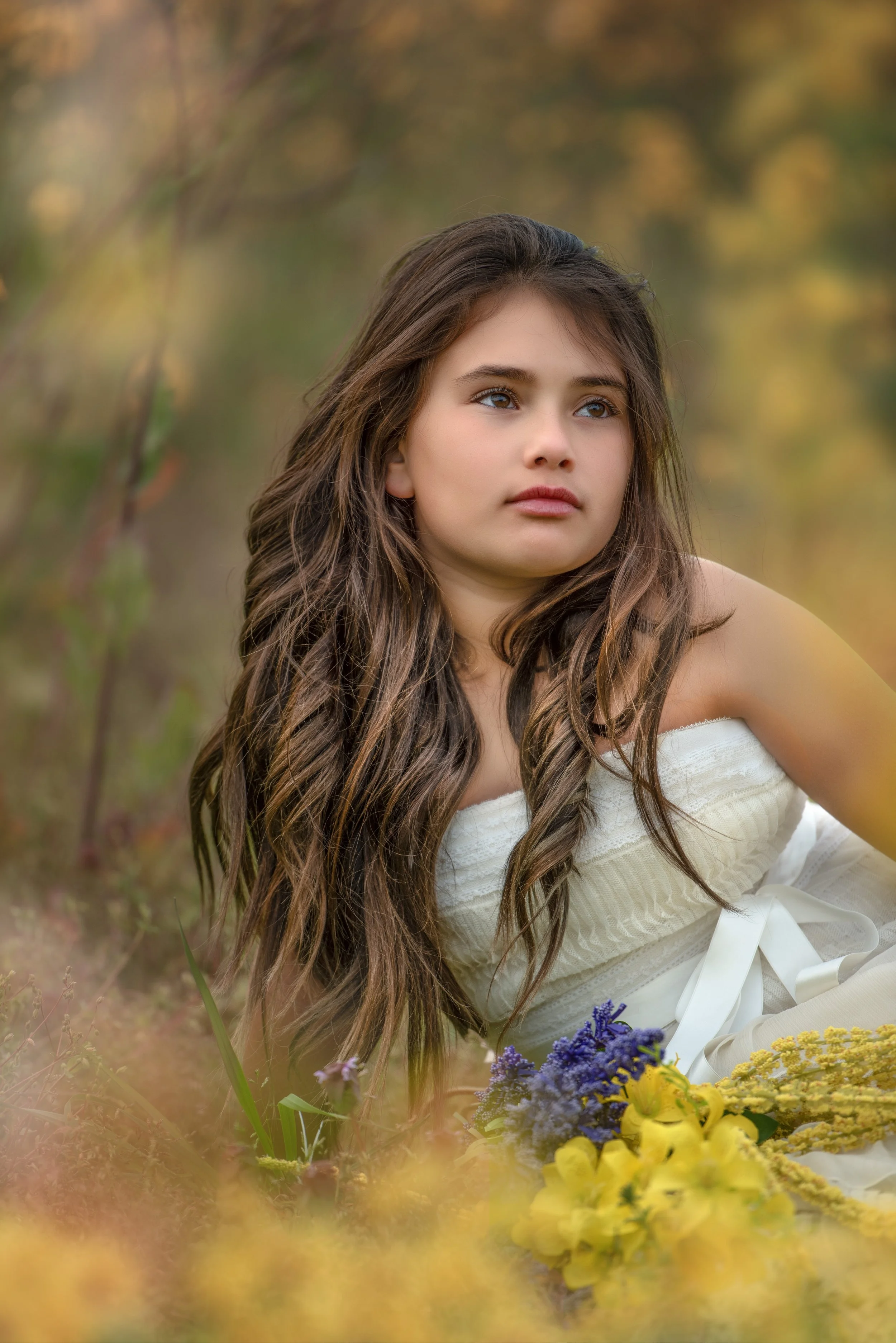 calgary children photographer girl sitting in yellow flowers.jpg