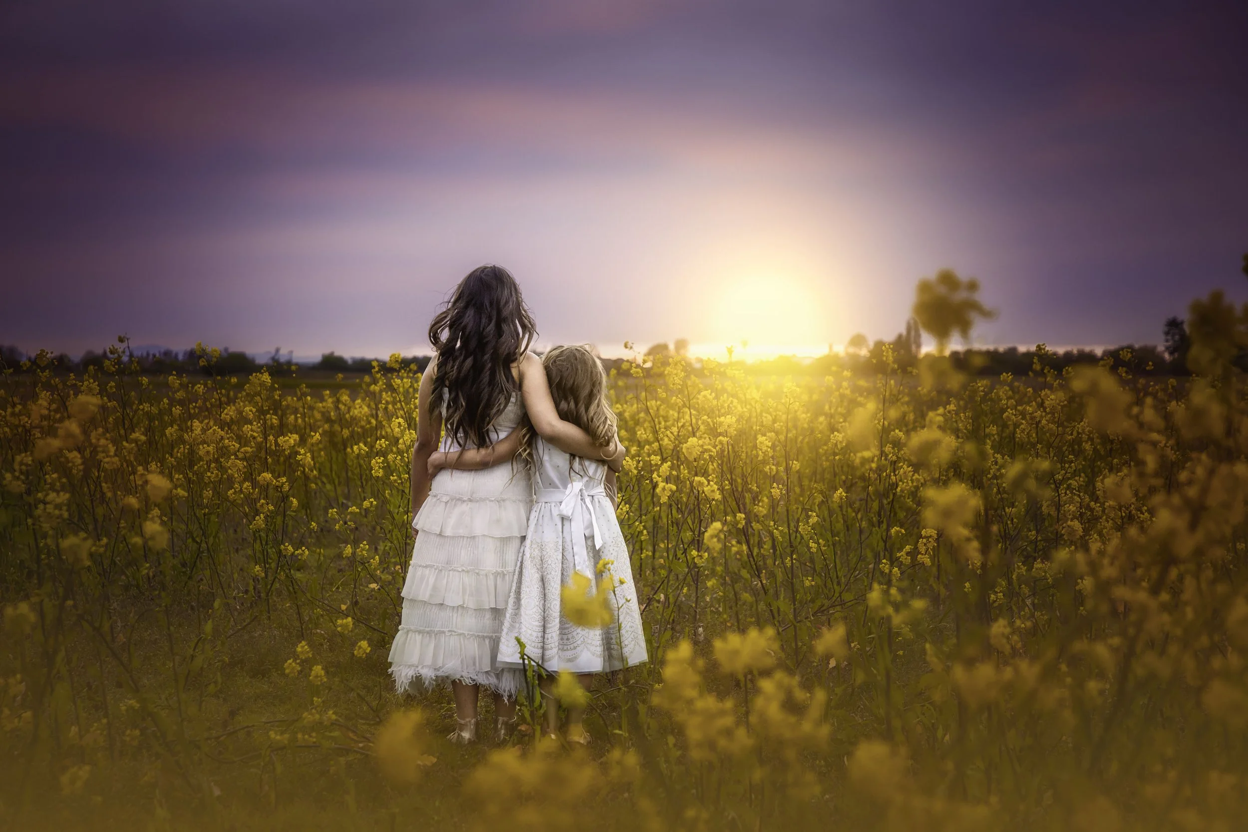 calgary children photographer sisters hugging woldflowers.jpg