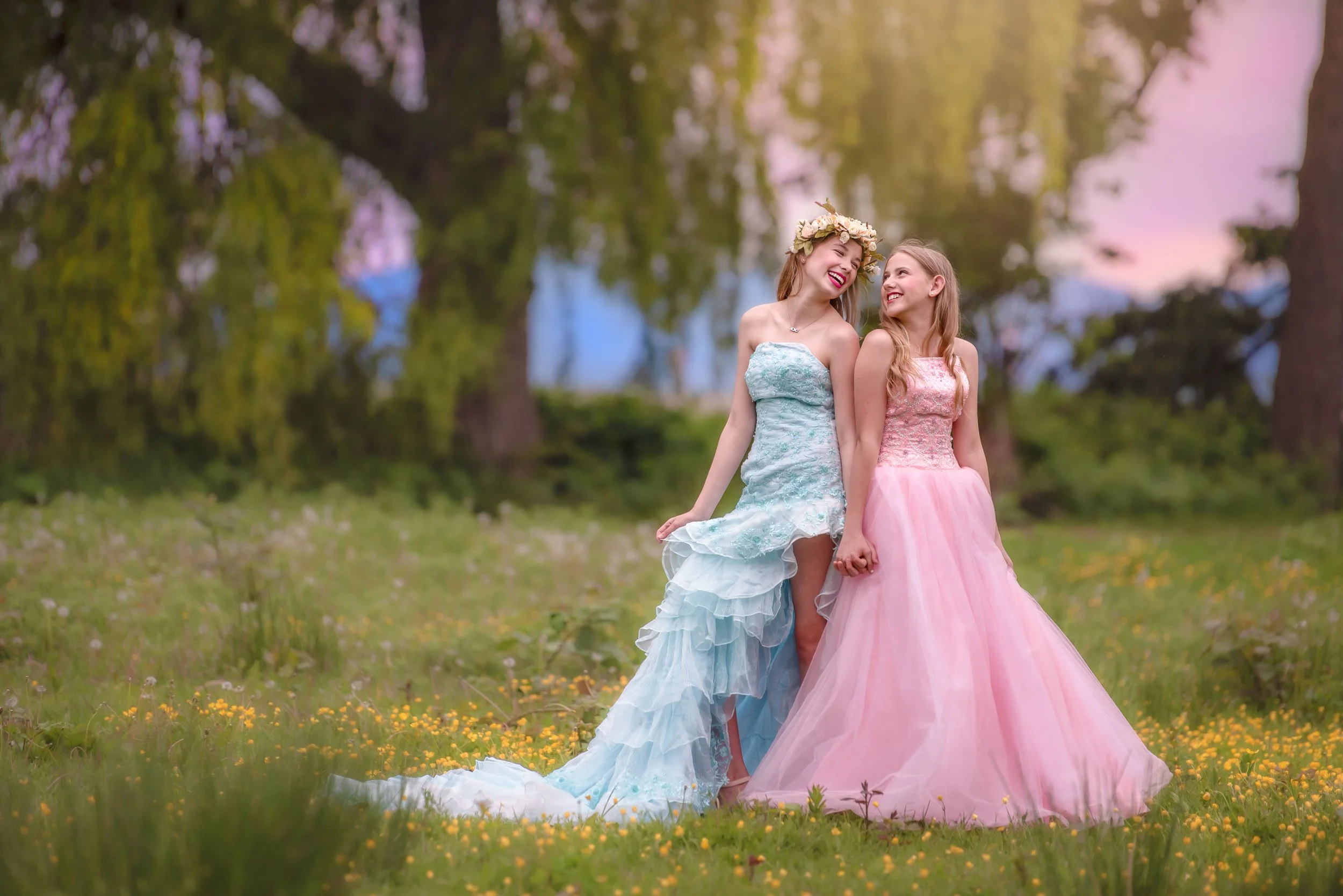 Calgary family photographer girls holding hands in big dresses laughing.jpg