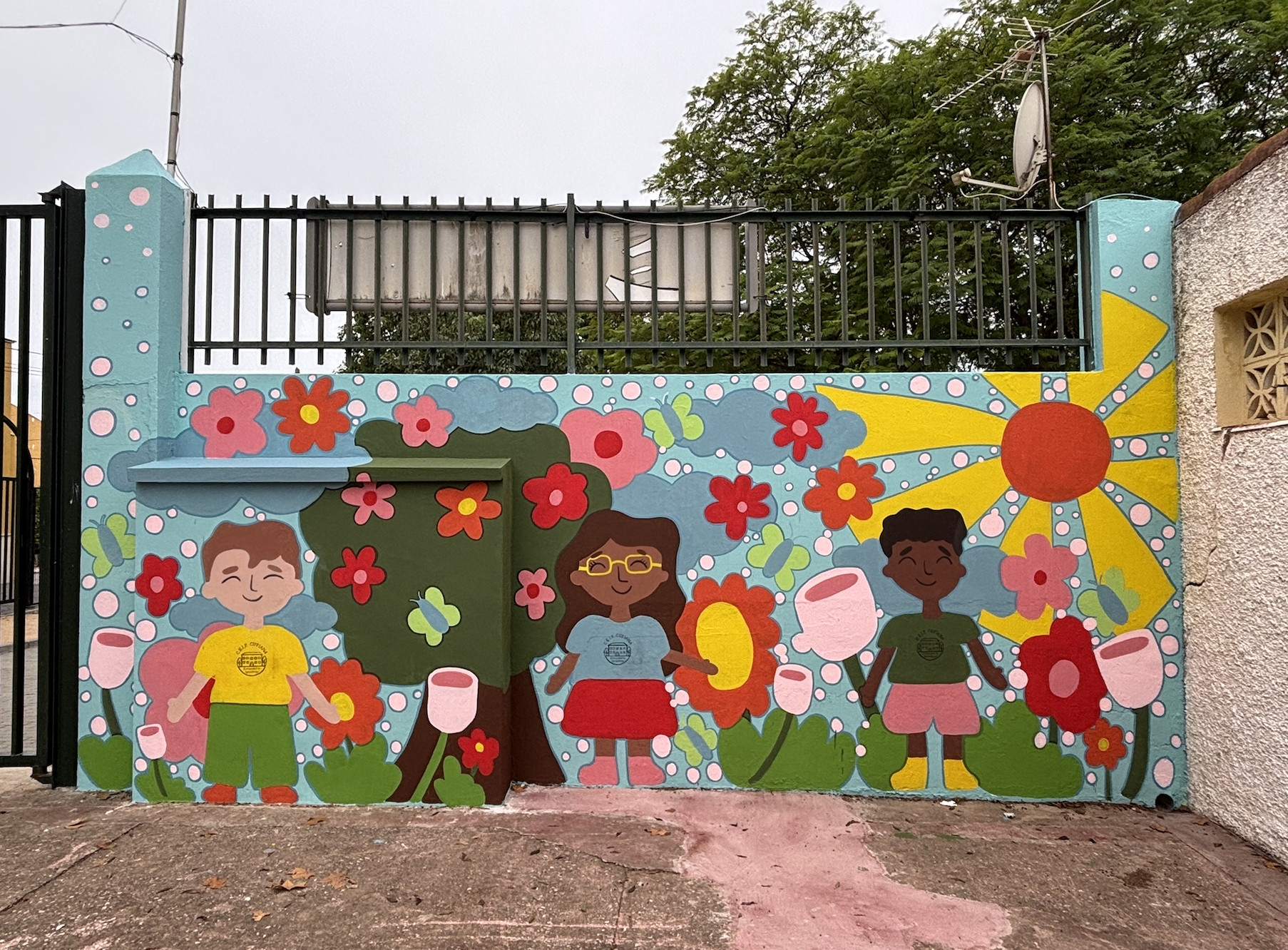After students finished painting, we spent a few days adding extra details and the school logo to their shirts. We traced the logo onto tracing paper and then onto the students' shirts. In some cases, varnishing/sealing the wall after you are done pa