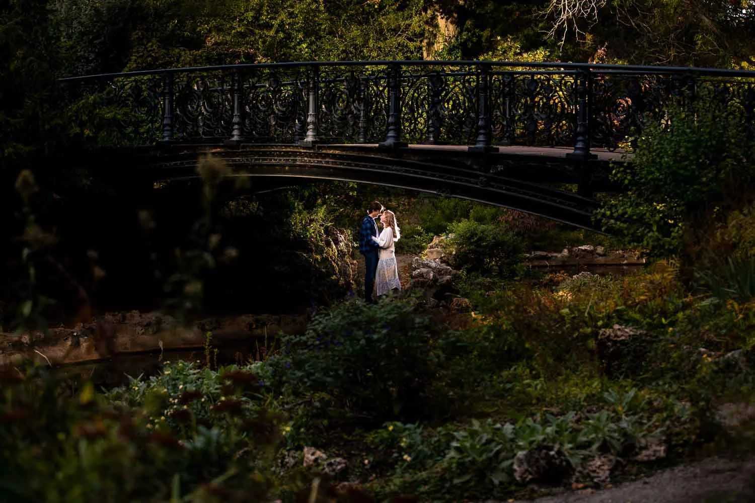 engaged couple cuddling under bridge in lafayette park -st louis engagement photography