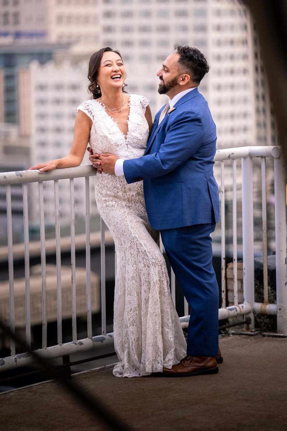 bride and groom overlook the city of st louis laughing