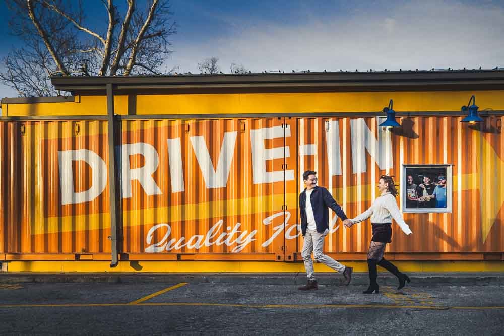 couple running through a parking lot holding hands-clayton engagement photography