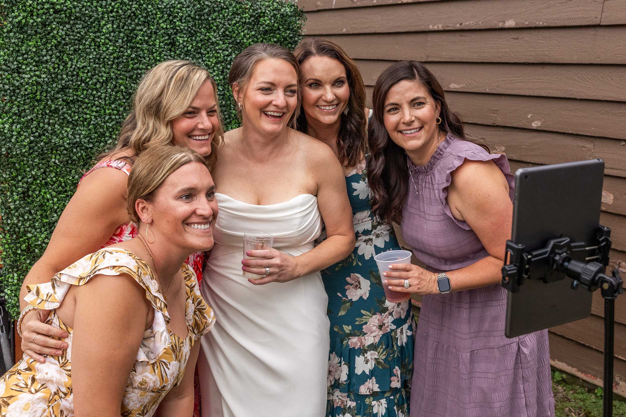 bride taking pictures with wedding guests in front of photo booth_Western Illinois