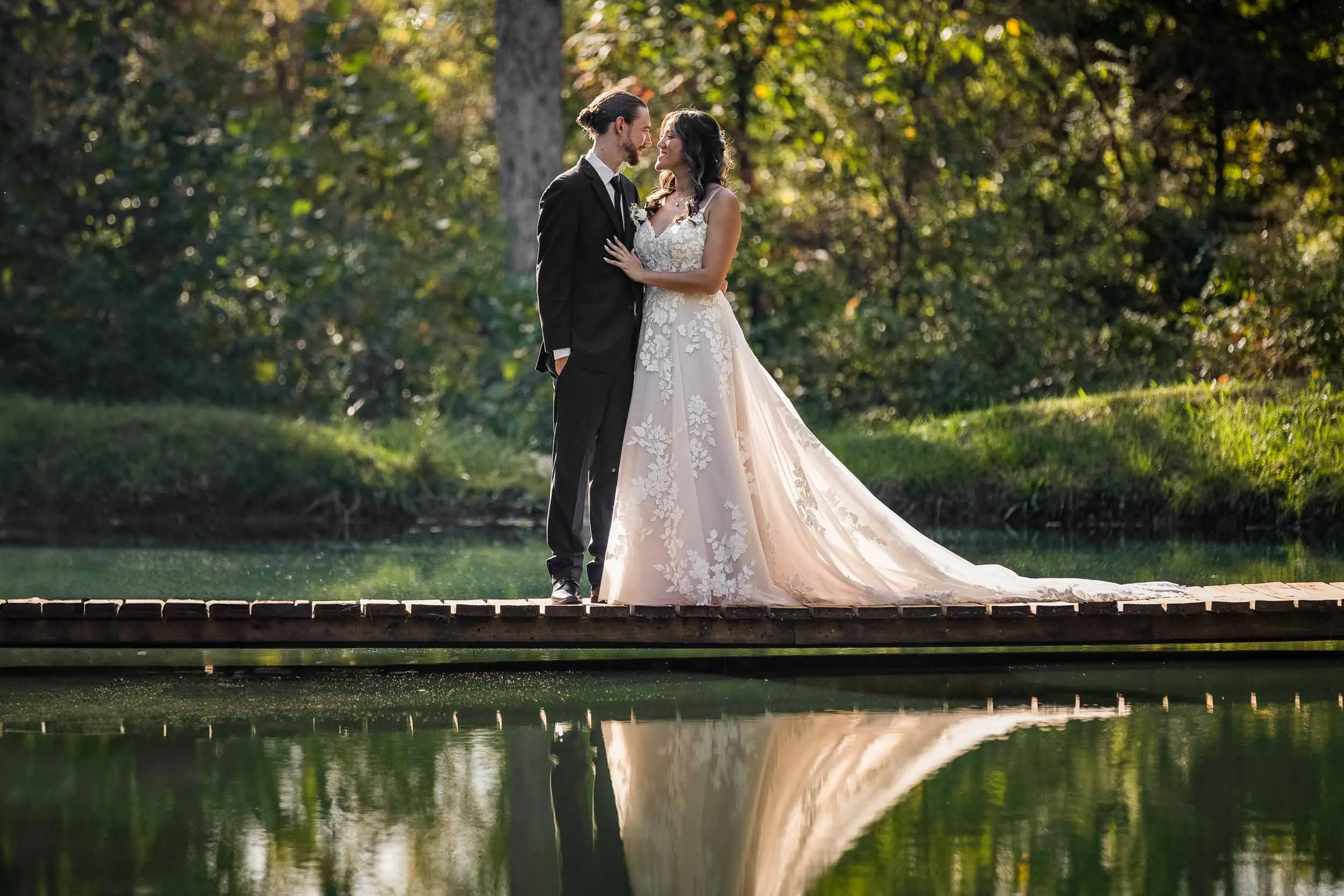 bride and groom standing on dock over lake_St Charles wedding portrait photography