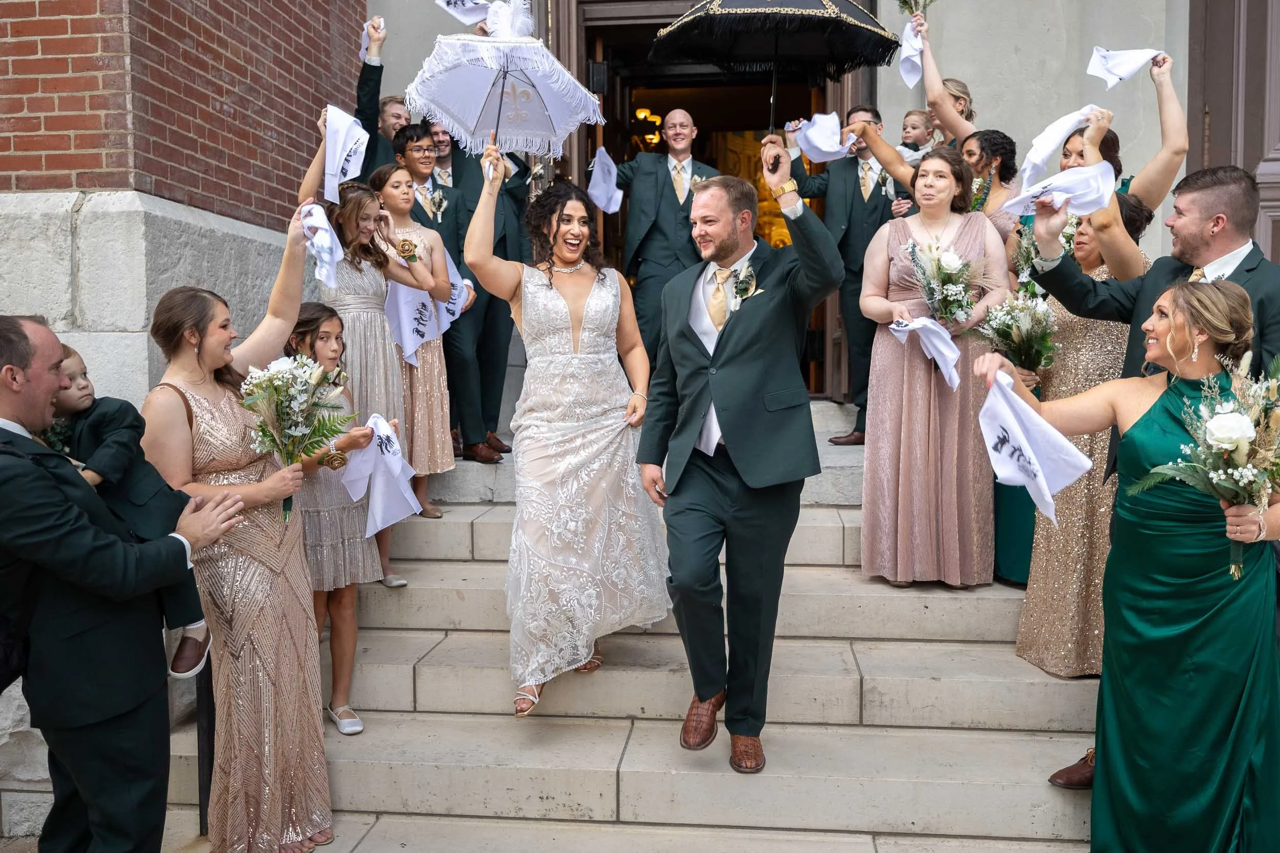 bride and groom coming out of church with umbrellas