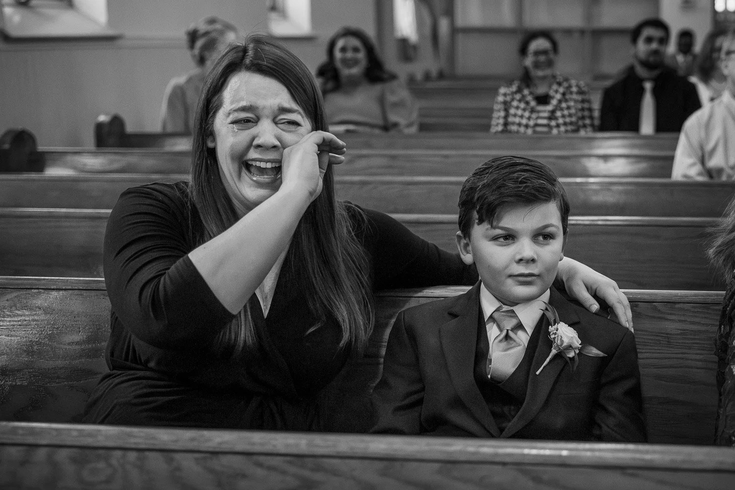 st louis documentary wedding photography of wedding guest crying in a church while sitting in a pew