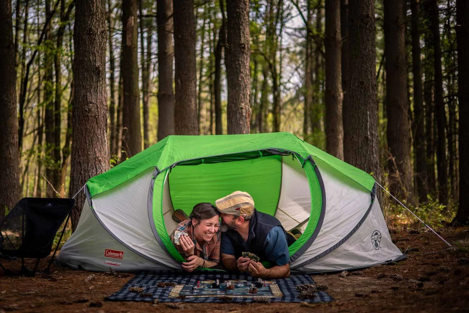 couple sitting in a tent while playing boardgames-engagement photography saint louis mo