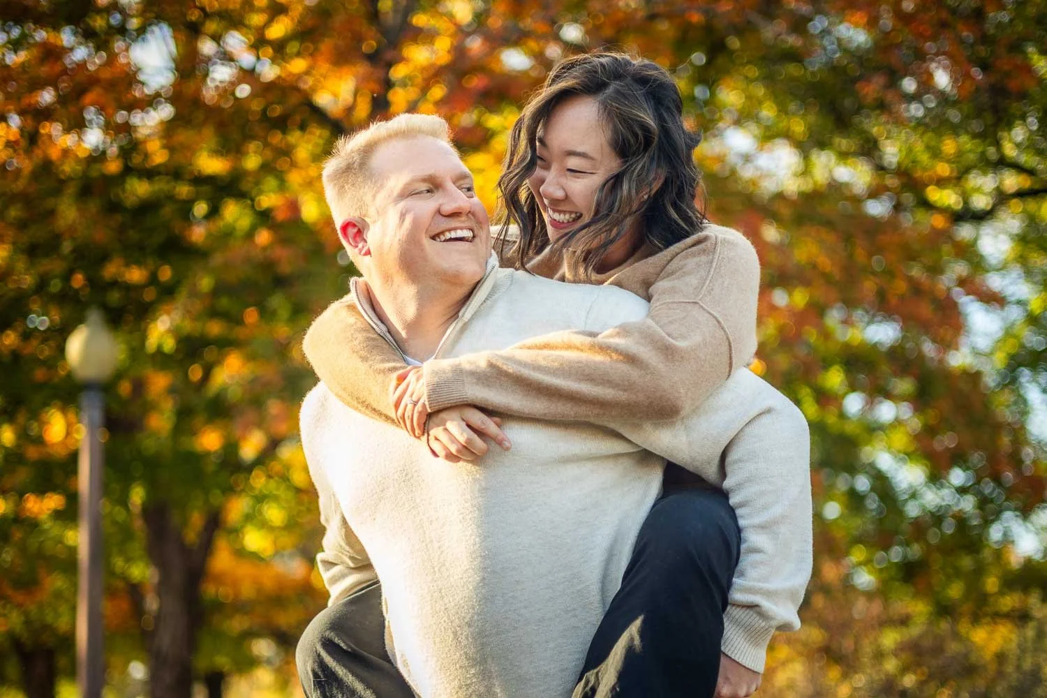 woman riding piggyback style on man's back - st louis engagement photographer