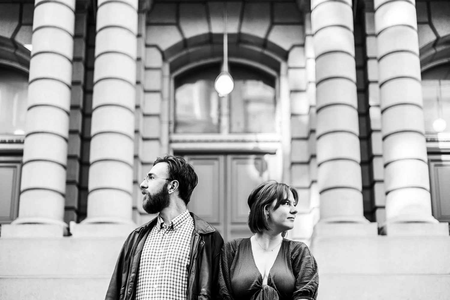 cute couple posing in urban enviroment with large pillars in the background-engagement photography saint louis