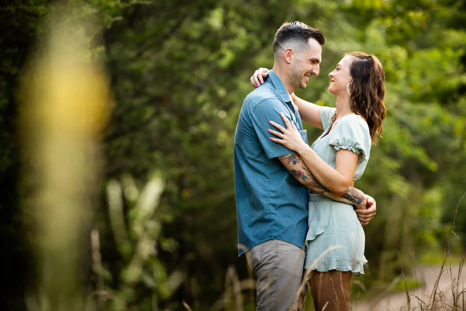 man holding woman in grassy field-engagement photography klondike park