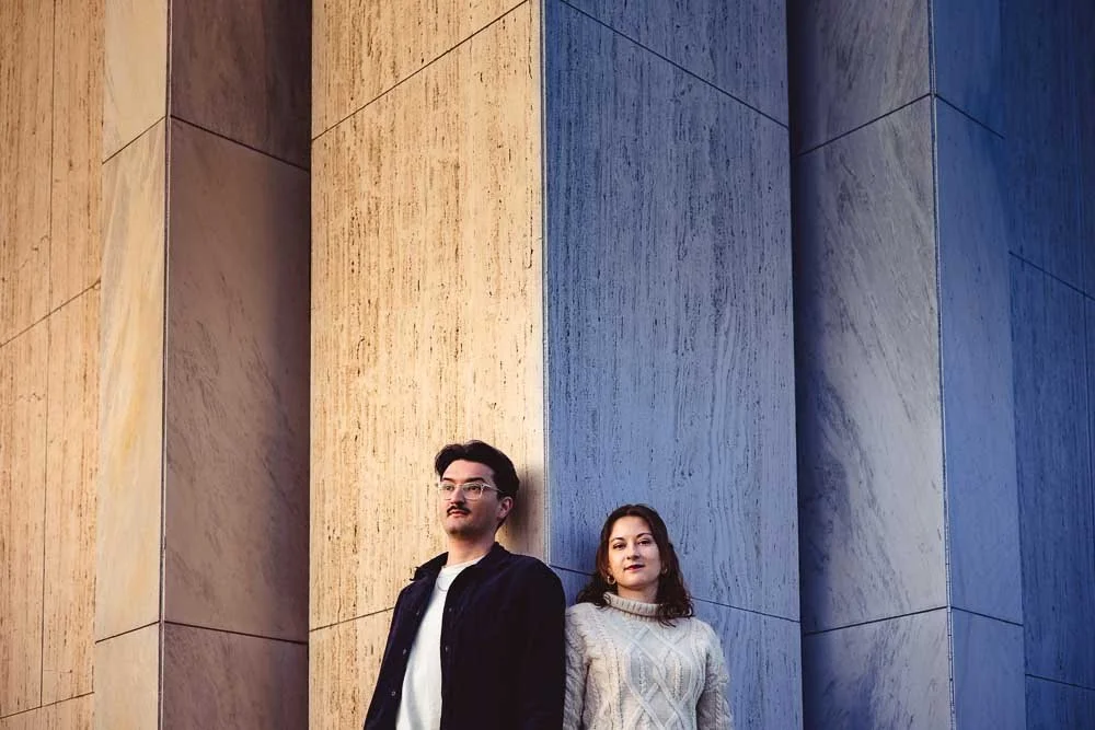 couple leaning against tall stone pillar-josh and lindsey photo