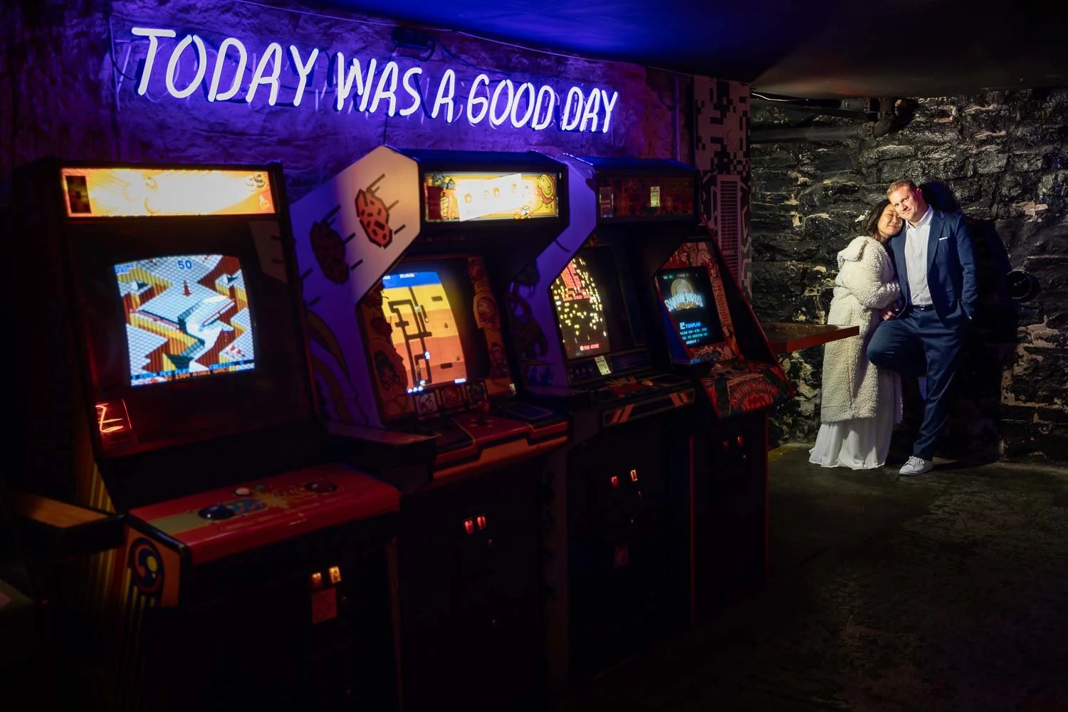 bride and groom snuggle in video arcade, saint louis wedding photography portrait