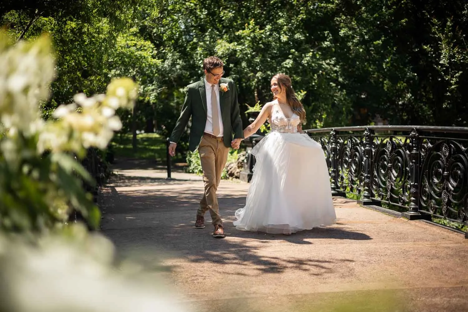 bride and groom walk over a bridge laughing and smiling in Lafayette Park - missouri wedding photographers josh and lindsey photo