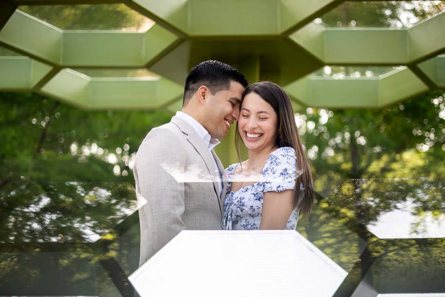 couple snuggling under an art sculpture in forest park-josh and lindsey photo