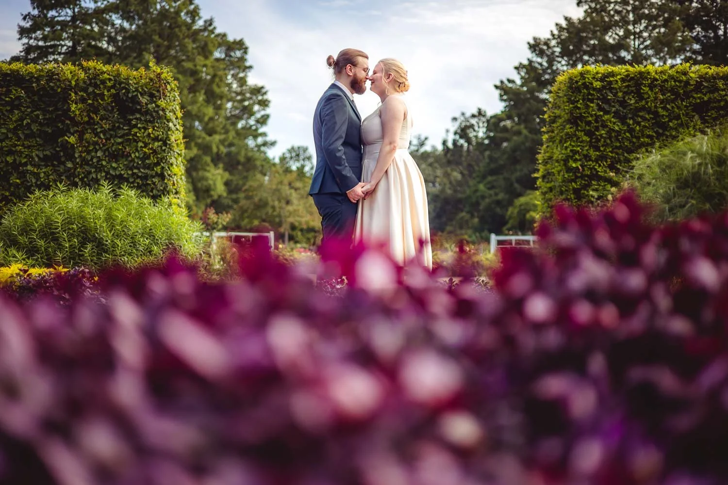 couple nose to nose in the lush flowers-st louis botanical gardens wedding photo