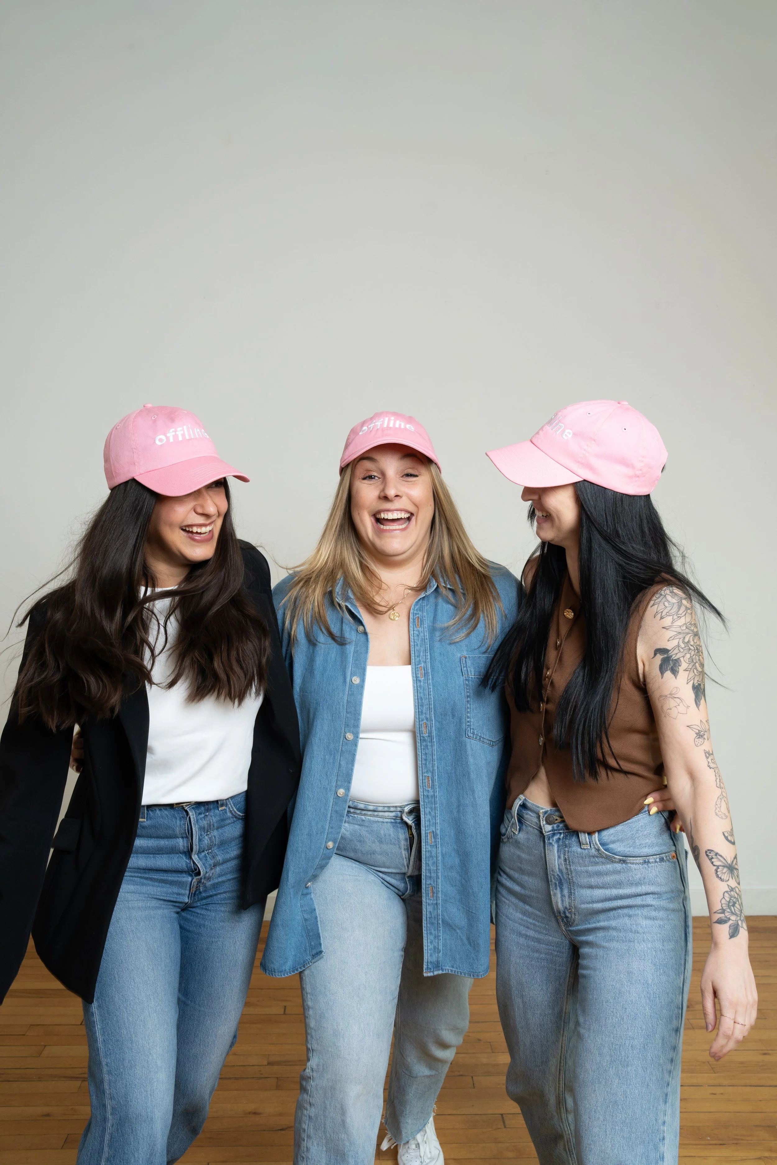 Women with pink hats smiling at each other