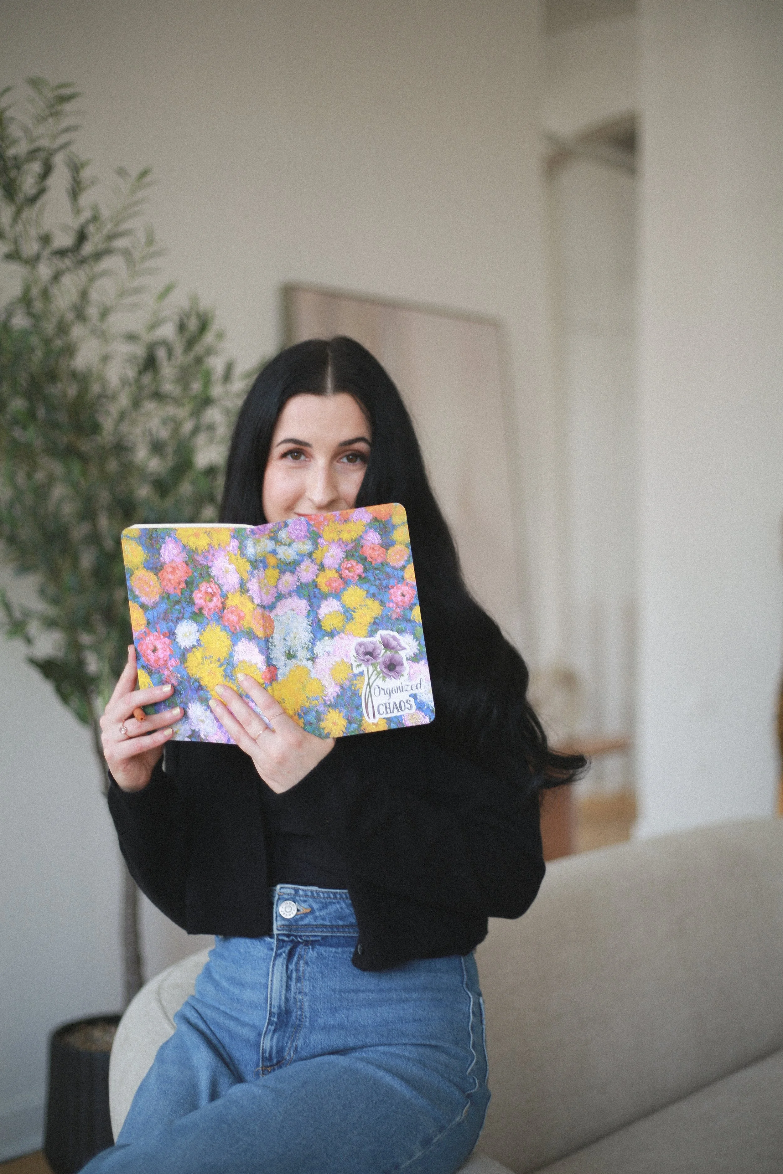 Woman smiling behind notebook