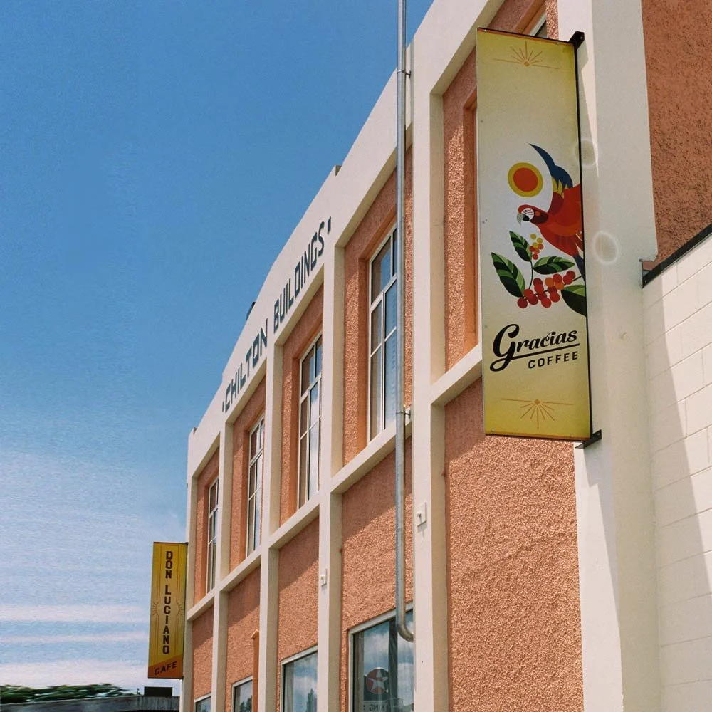 Exterior of Chilton Buildings with coffee shop signs, including "Gracias Coffee" and "Don Luciano Cafe."
