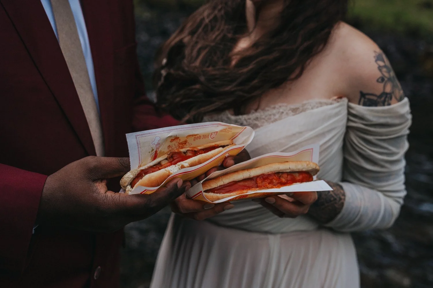 An eloping couple eats Icelandic hot dogs in Iceland on their elopement day