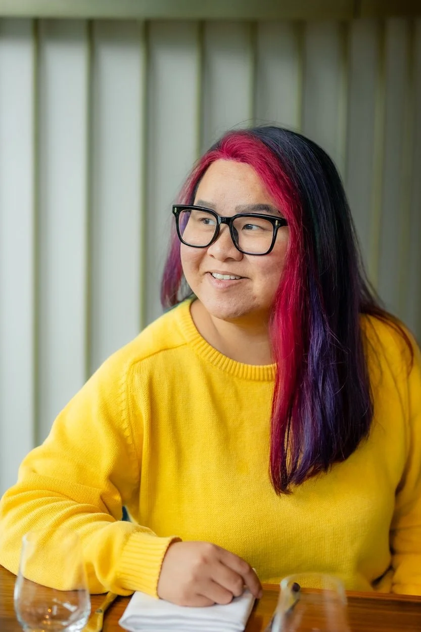 The image of a bipoc, queer, youth, transgender therapist Vancouver smiling at the camera  to accompany a service page about LGBTQ+ therapy