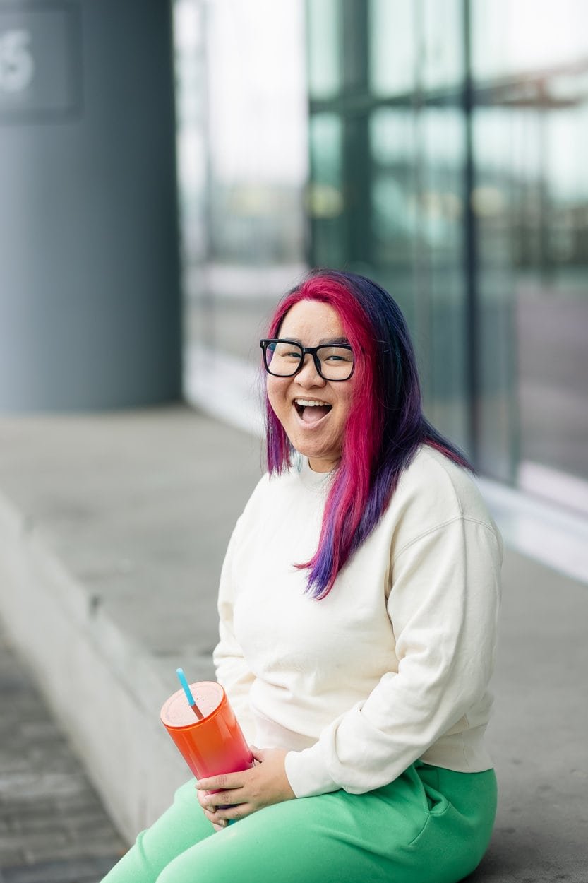 The image of a bipoc, queer, youth, transgender therapist Vancouver smiling at the camera  to accompany a service page about LGBTQ+ therapy