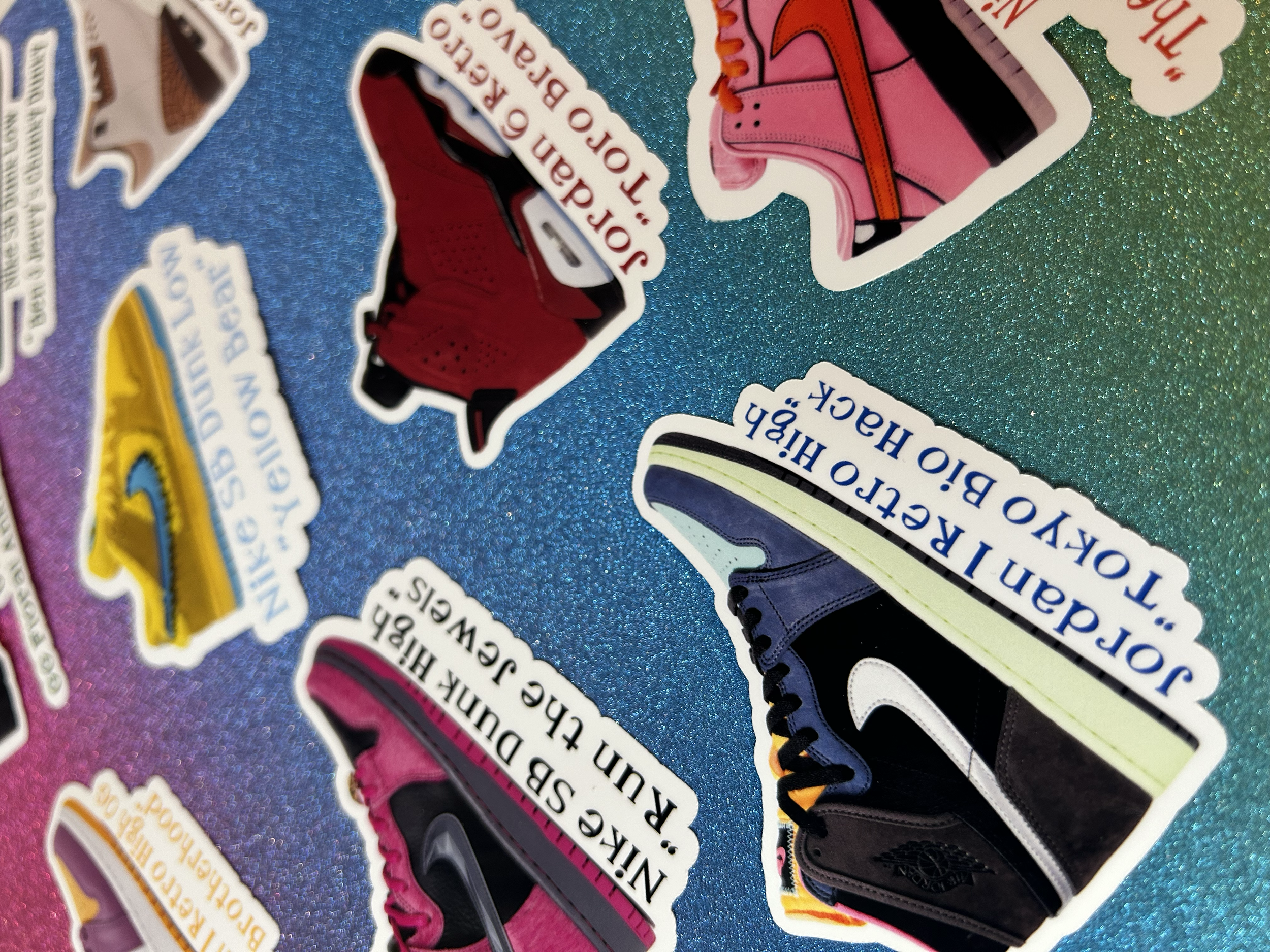 Stickers of various colorful sneakers with names and descriptions on a sparkly blue background.
