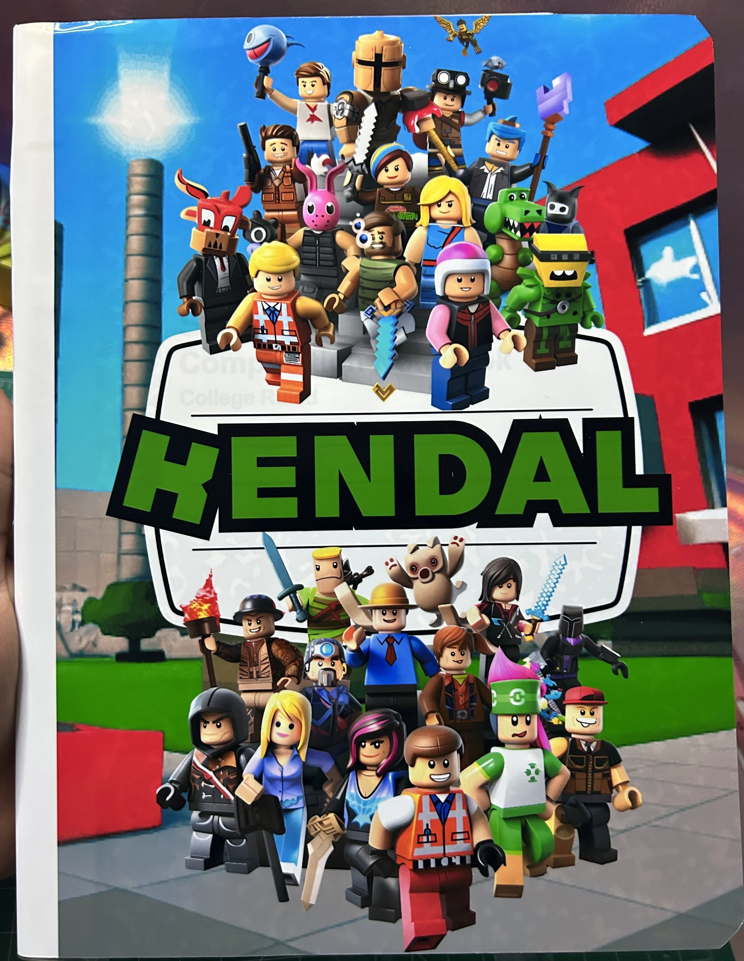 Illustration featuring Lego-style characters with various outfits and accessories in front of a modern building, with "KENDAL" prominently displayed in green text.